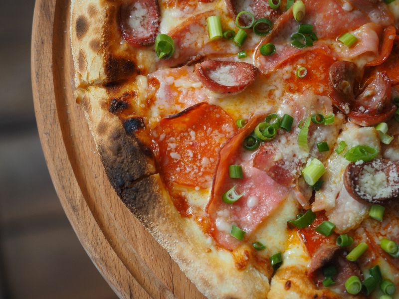 Fresh pizza toppings at Mod Pizza preparation station